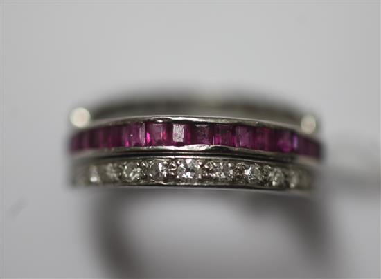 A mid 20th century platinum, sapphire, ruby and diamond triple band swivel ring, size M.